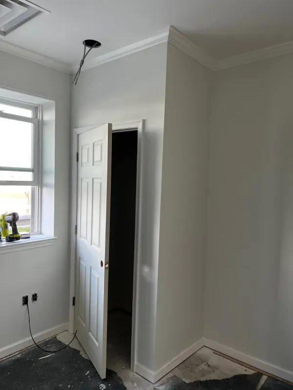 A room with a door open and a window.