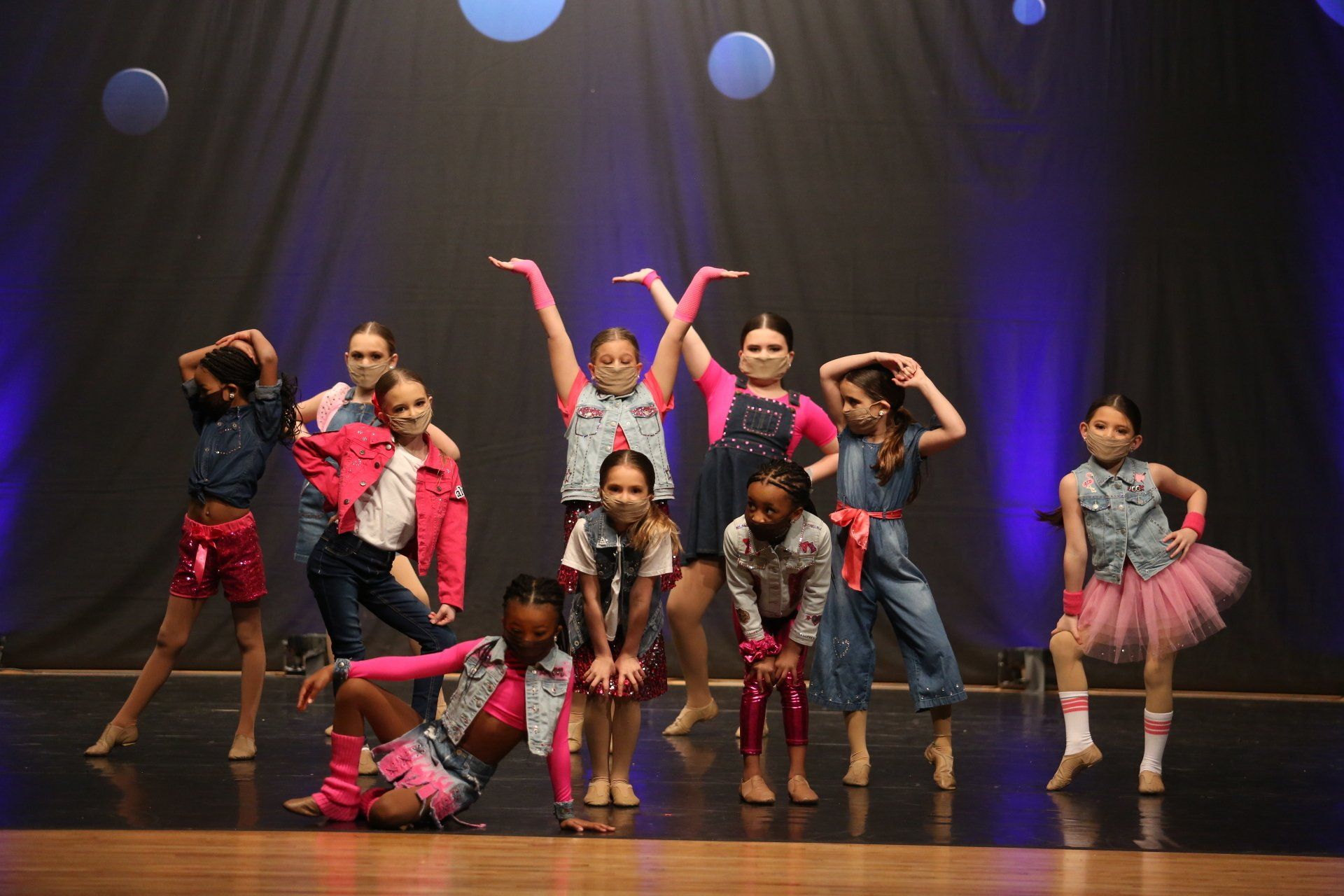 A group of young girls are dancing on a stage.