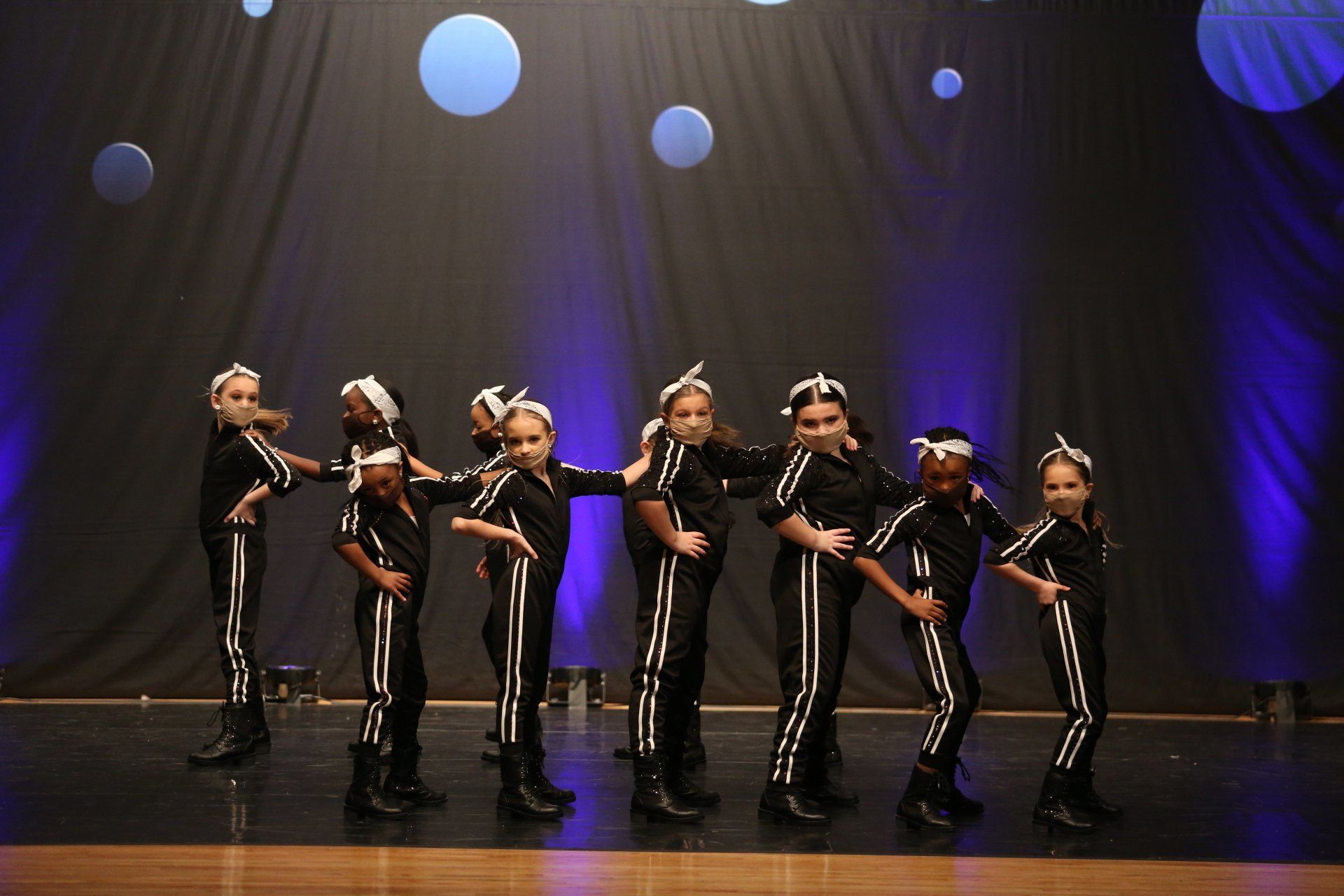 A group of young girls are dancing on a stage.