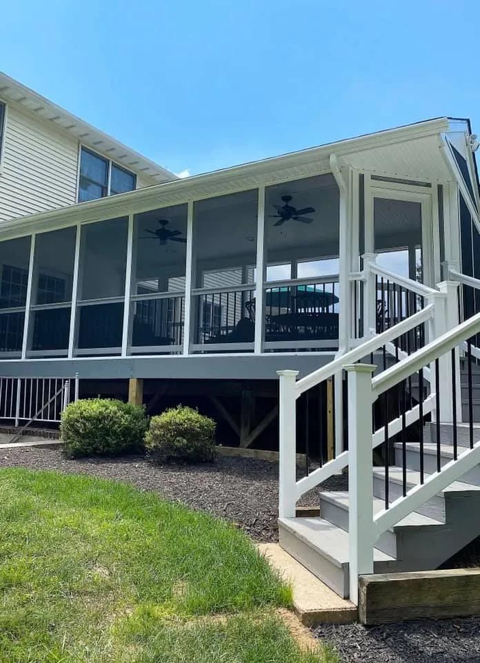 There is a screened in porch with stairs leading up to it.