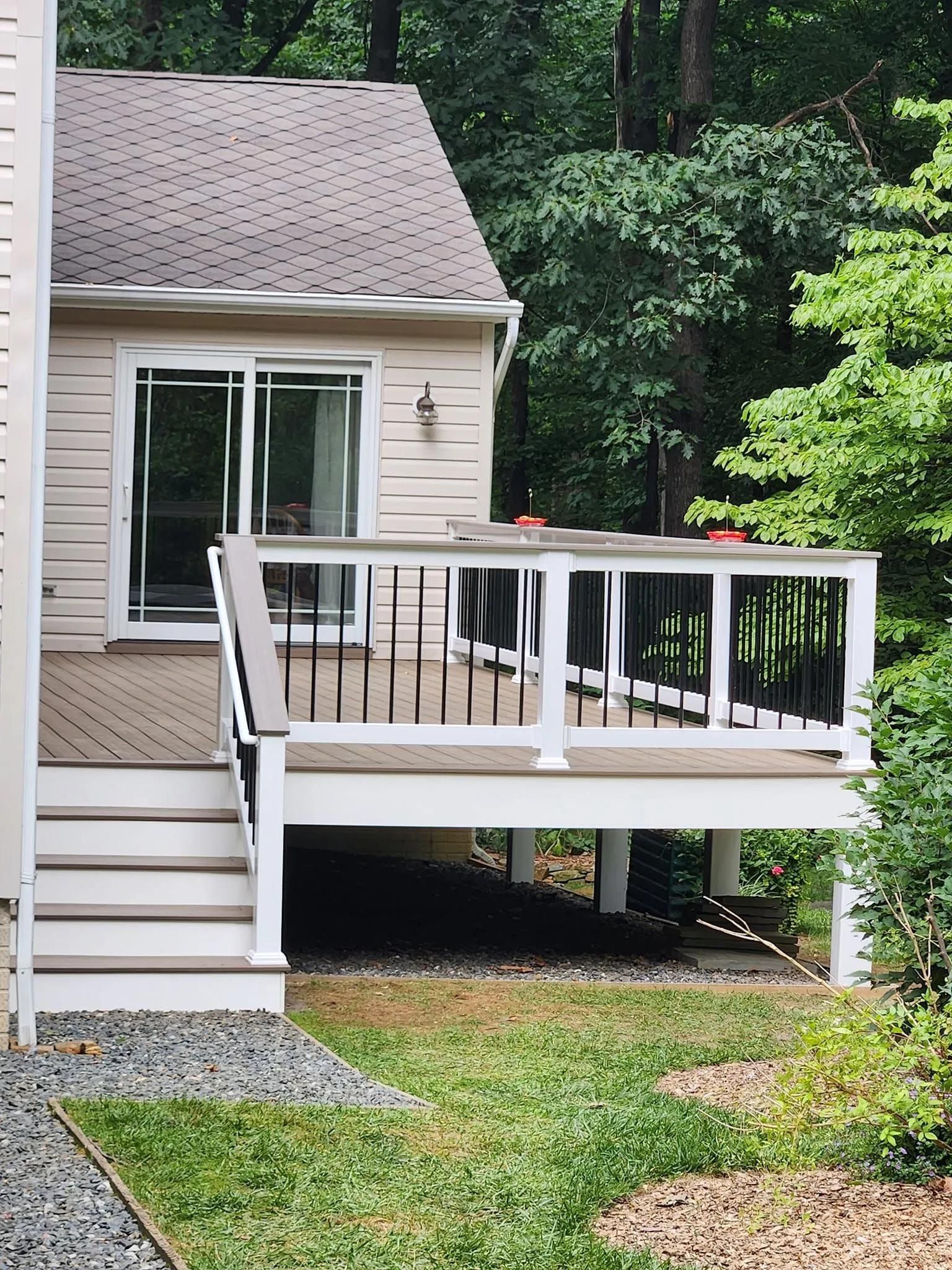 A small house with a deck and a sliding glass door