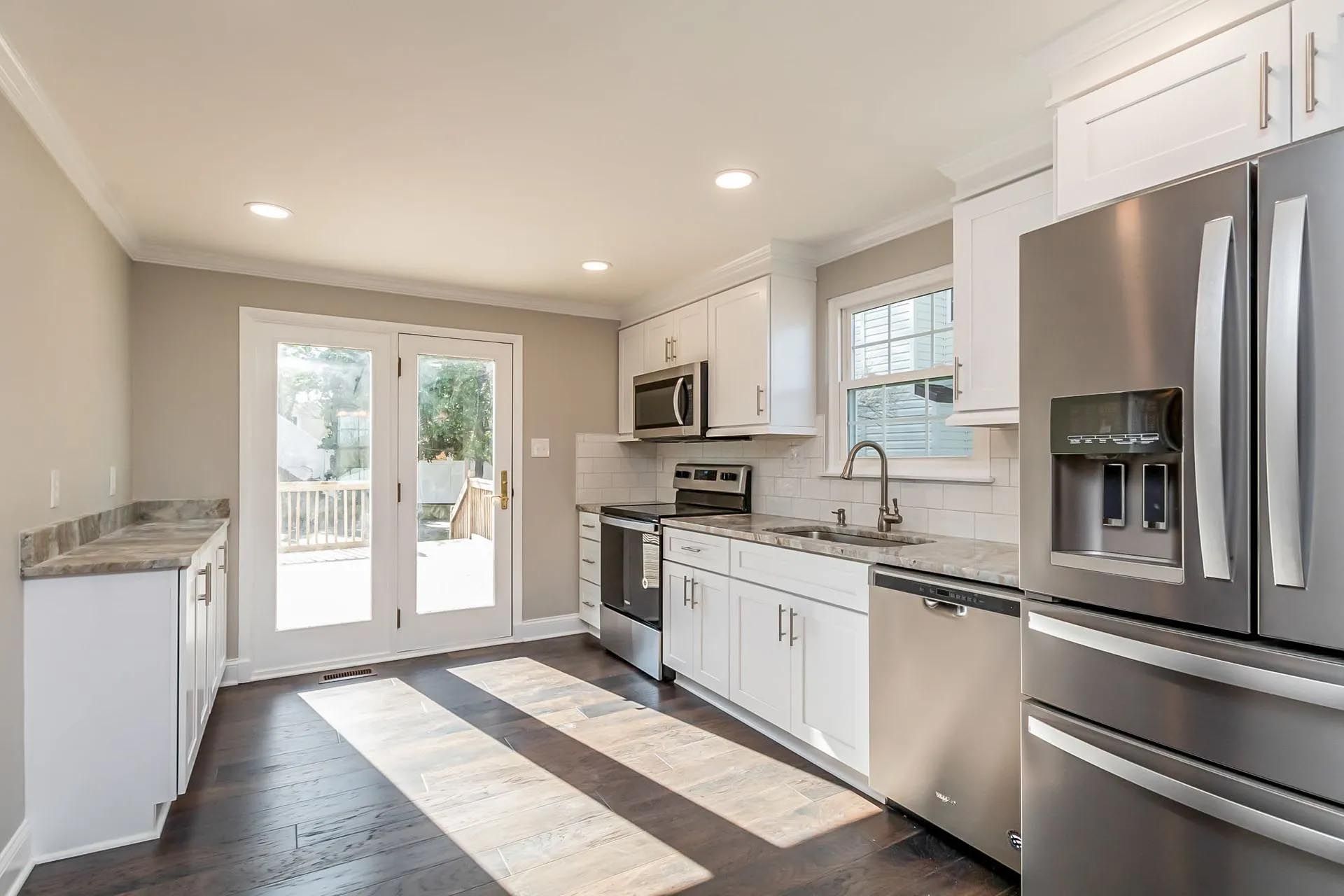 A kitchen with stainless steel appliances and white cabinets.