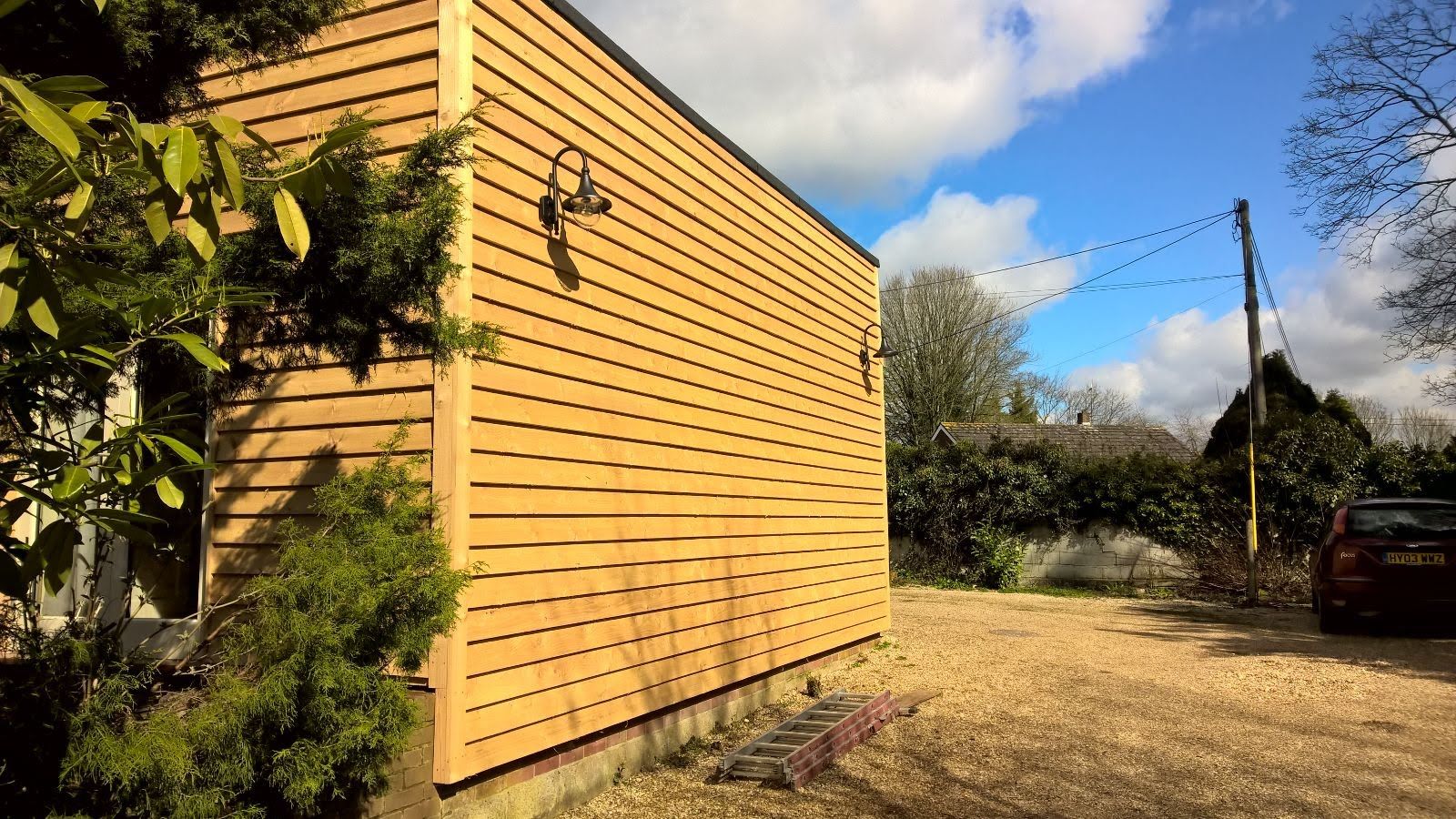 A wooden building with a car parked in front of it.