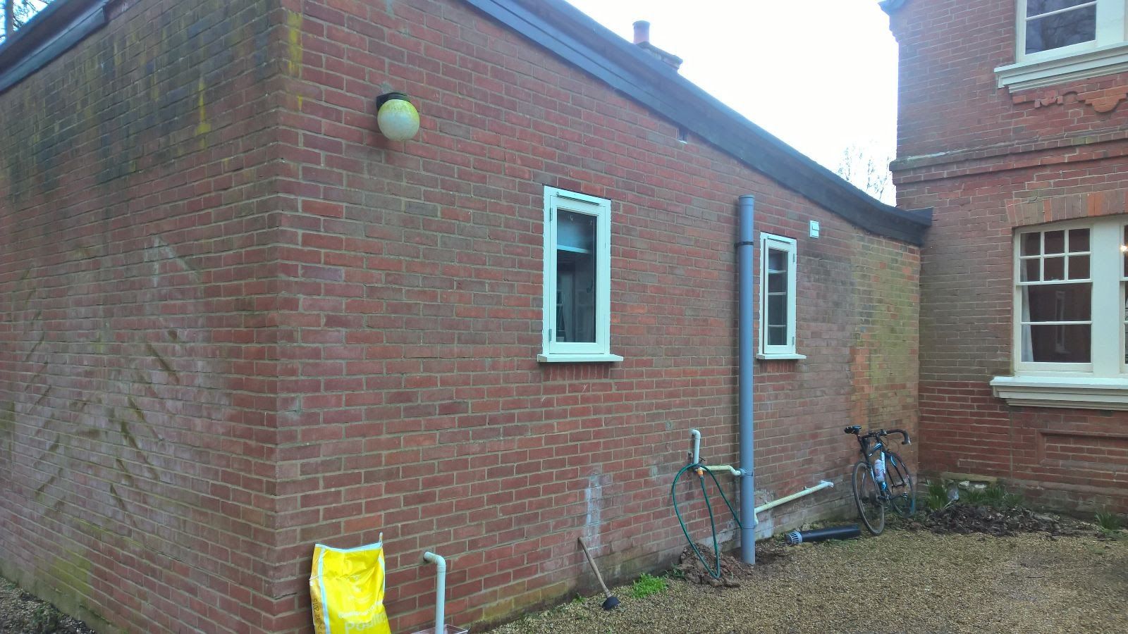 A brick building with a bicycle parked in front of it.