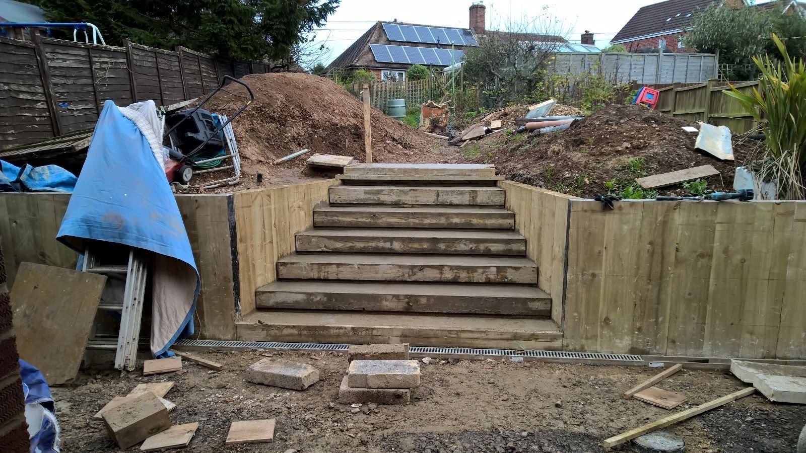 A group of stairs are being built in a backyard.