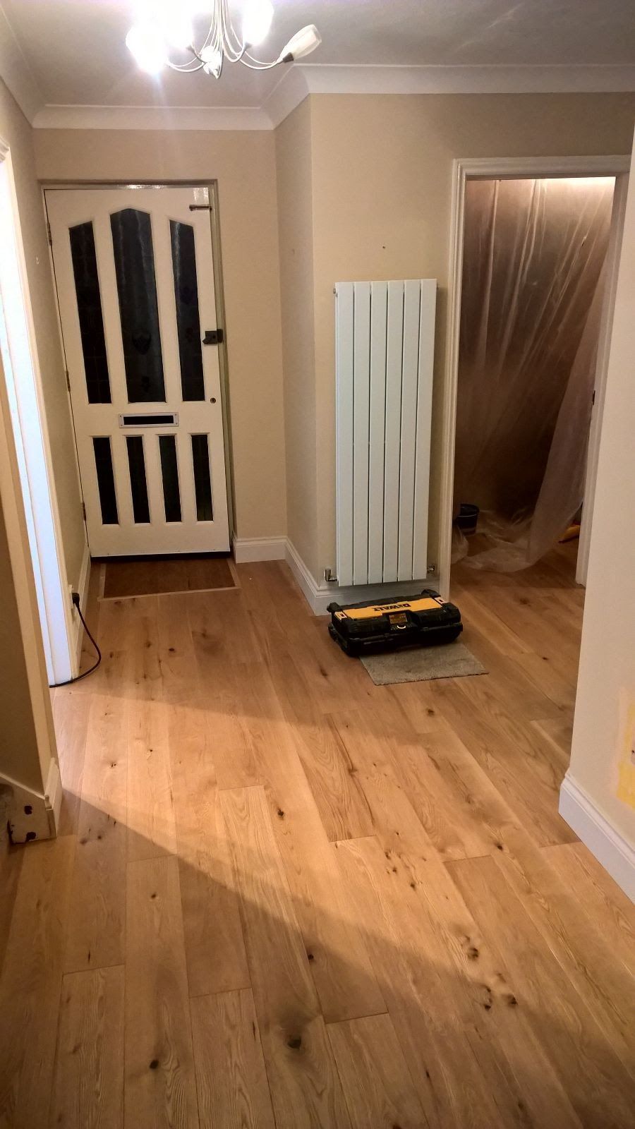 A hallway with hardwood floors and a white radiator.