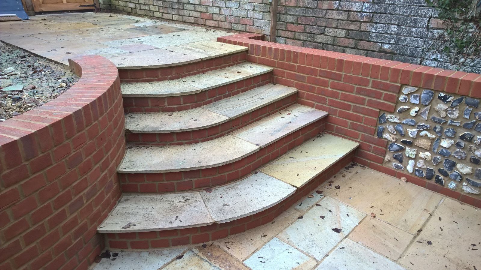 A set of stairs leading up to a brick wall.