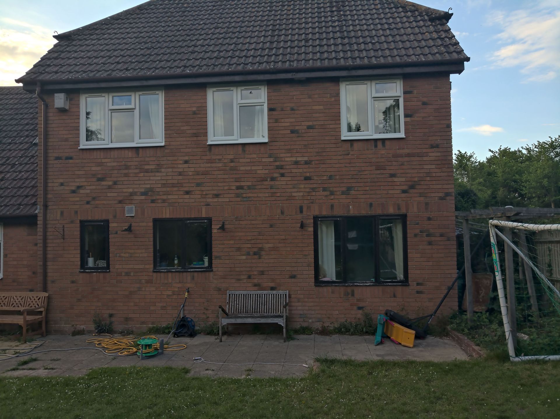 A large brick house with a soccer goal in the backyard.