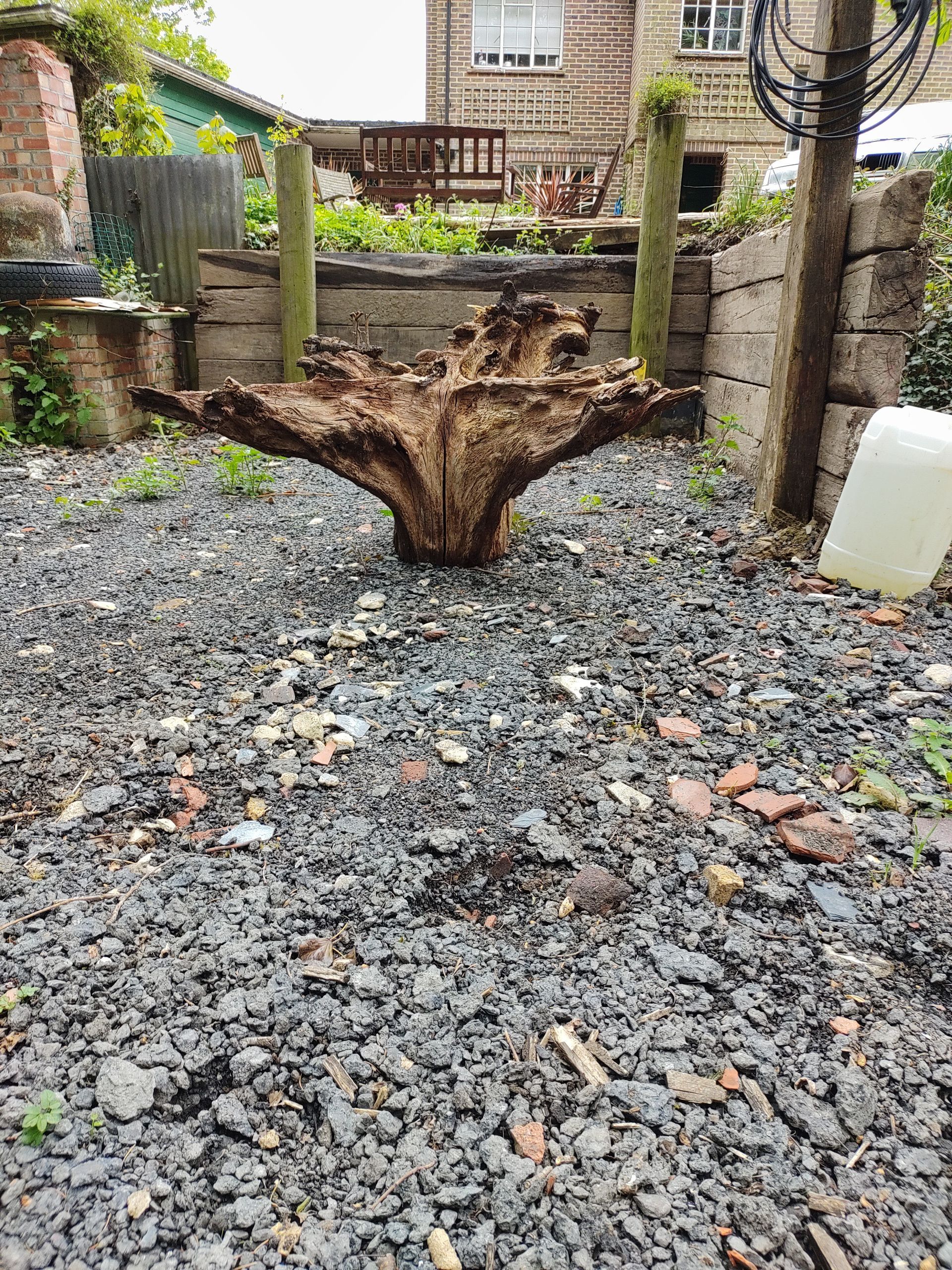 A large piece of wood is sitting on top of a pile of gravel.