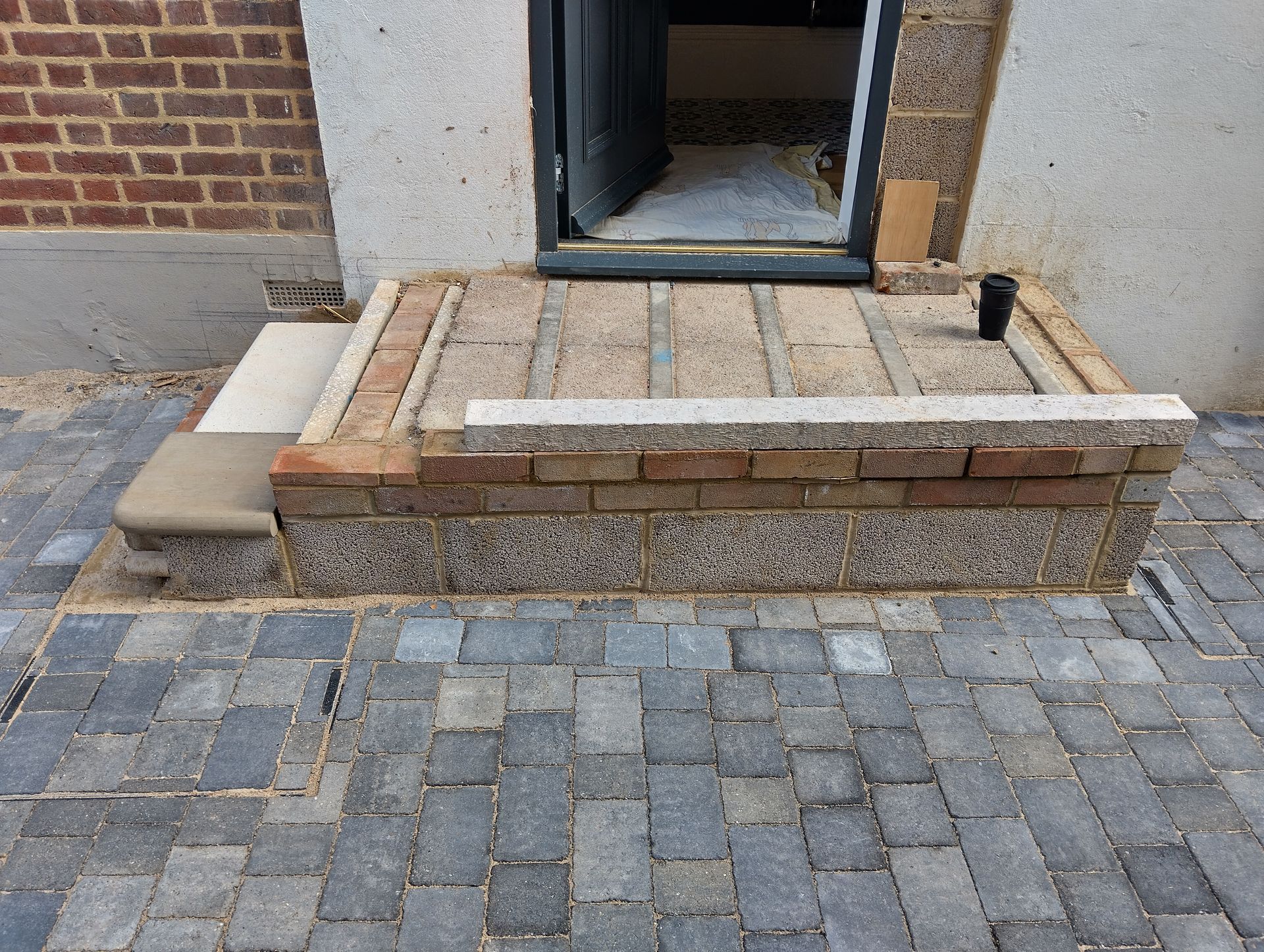 A brick walkway is being built in front of a brick building.