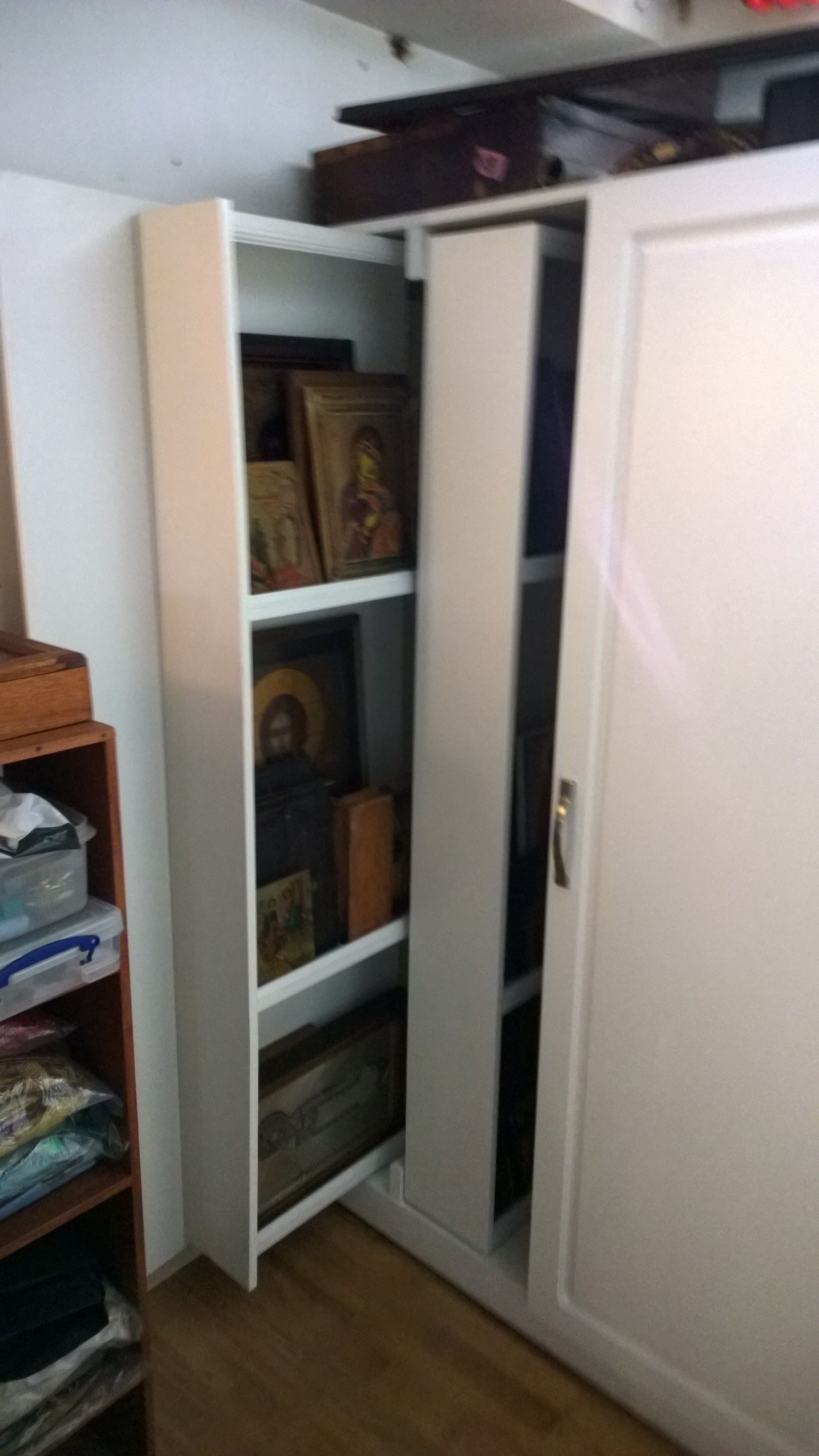 A closet with a sliding door and shelves filled with various items