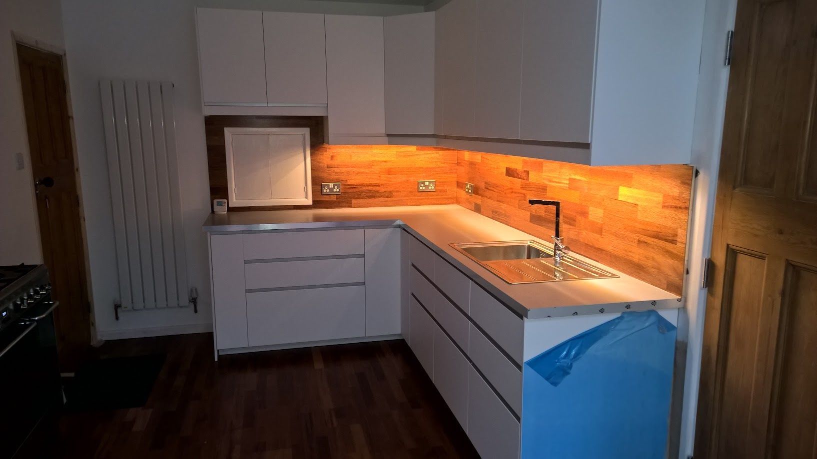 A kitchen with white cabinets , a sink , and a stove.