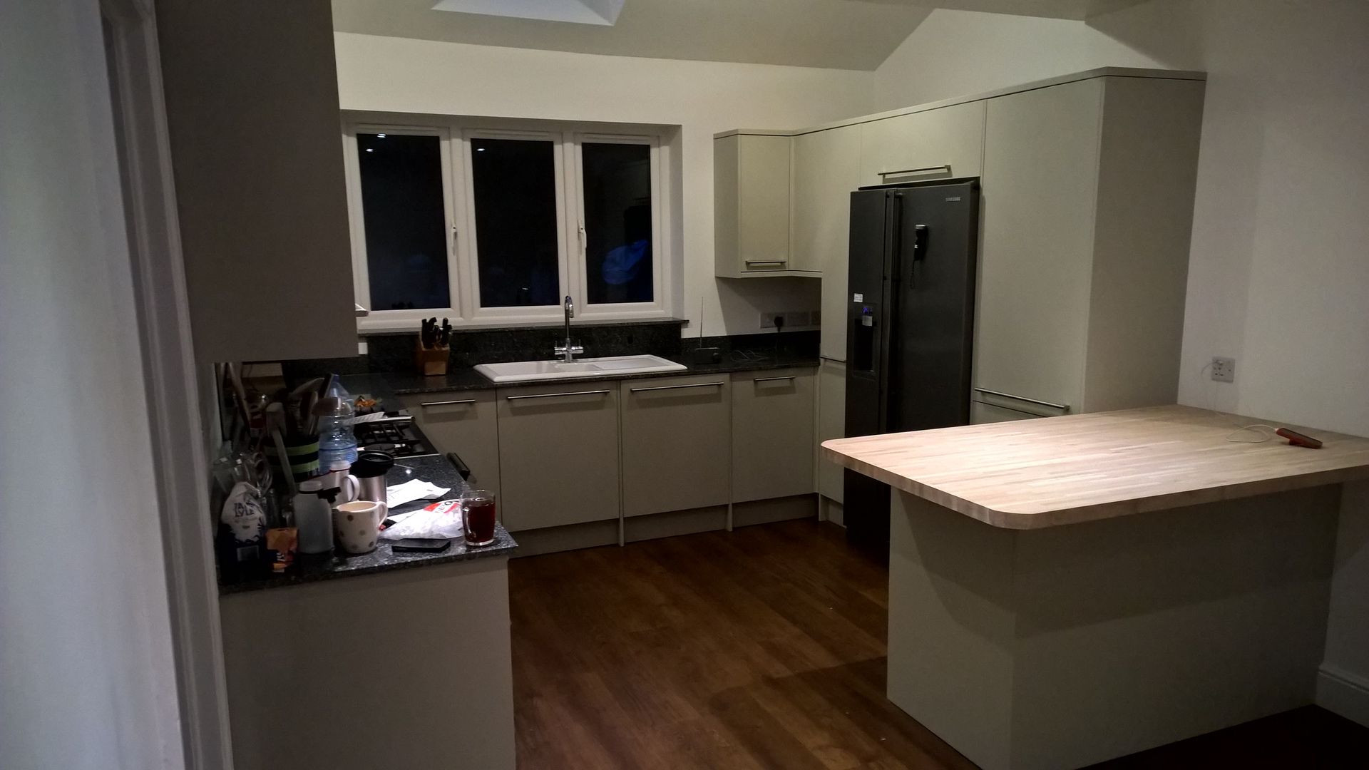A kitchen with white cabinets and a black refrigerator.