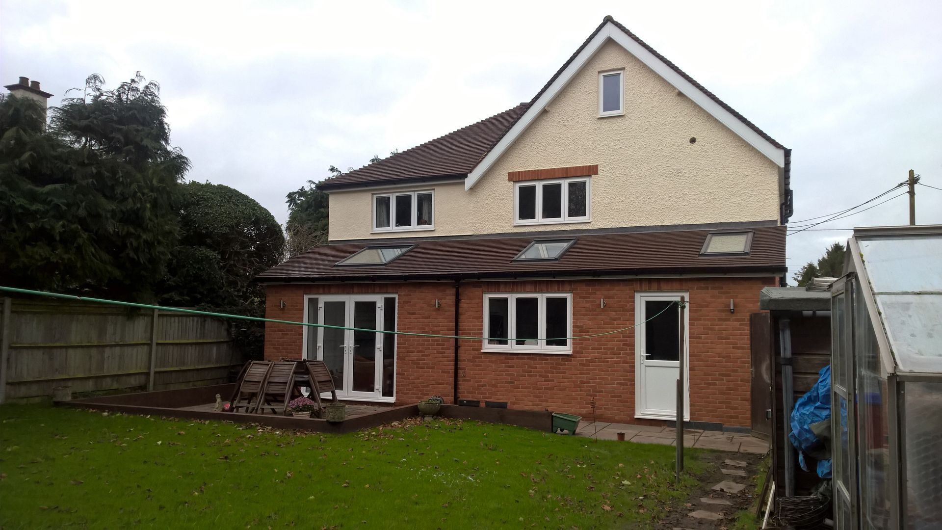 The back of a house with a fence in the background