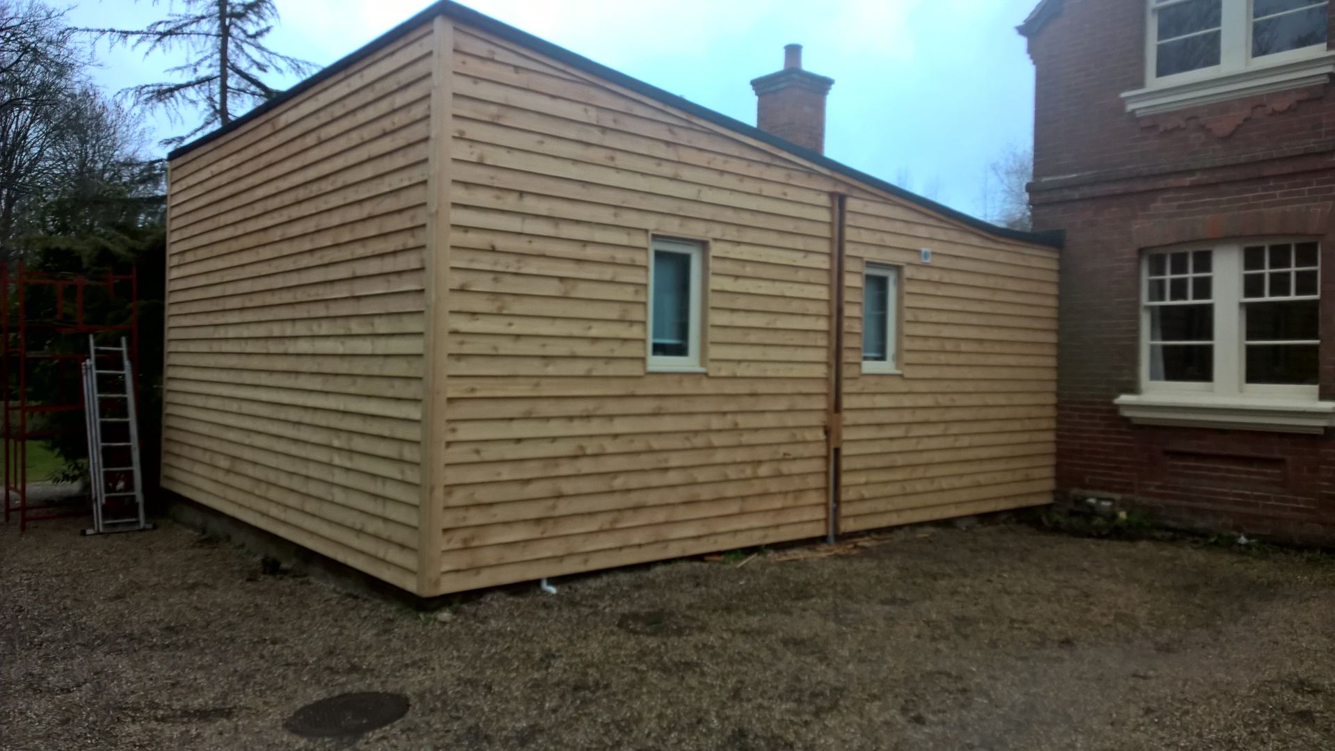 A wooden building with a ladder in front of it