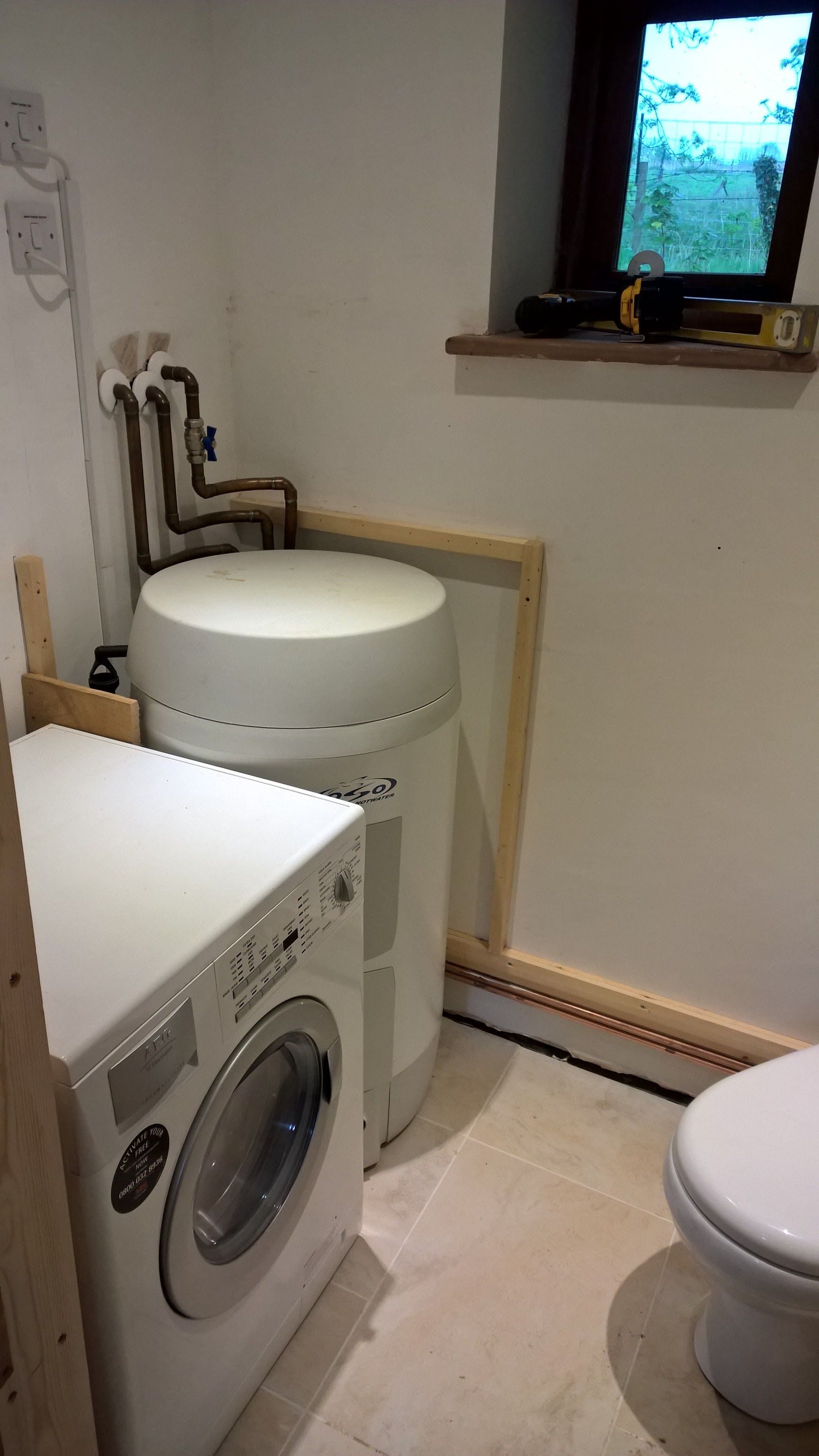 A bathroom with a washer and dryer and a toilet.
