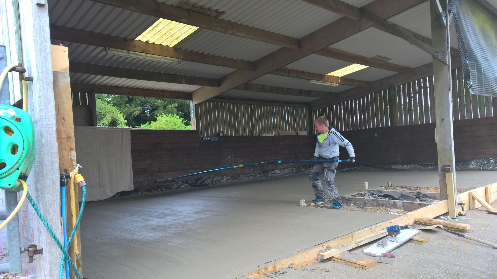 A man is working on a concrete floor in a building.
