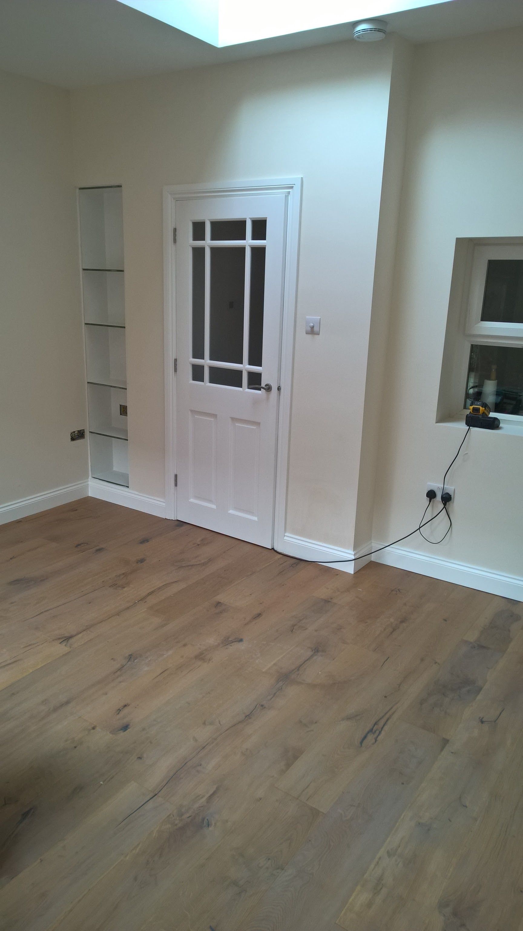 A living room with hardwood floors and a white door.