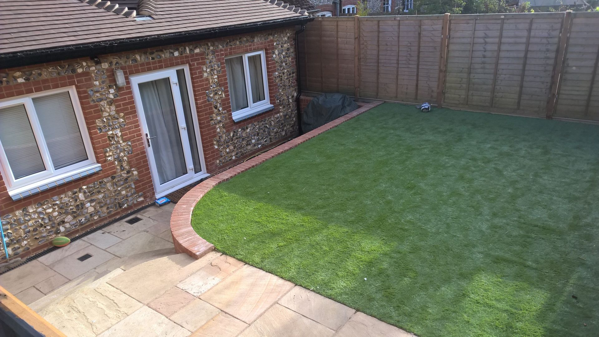 A brick house with a large lawn in front of it.