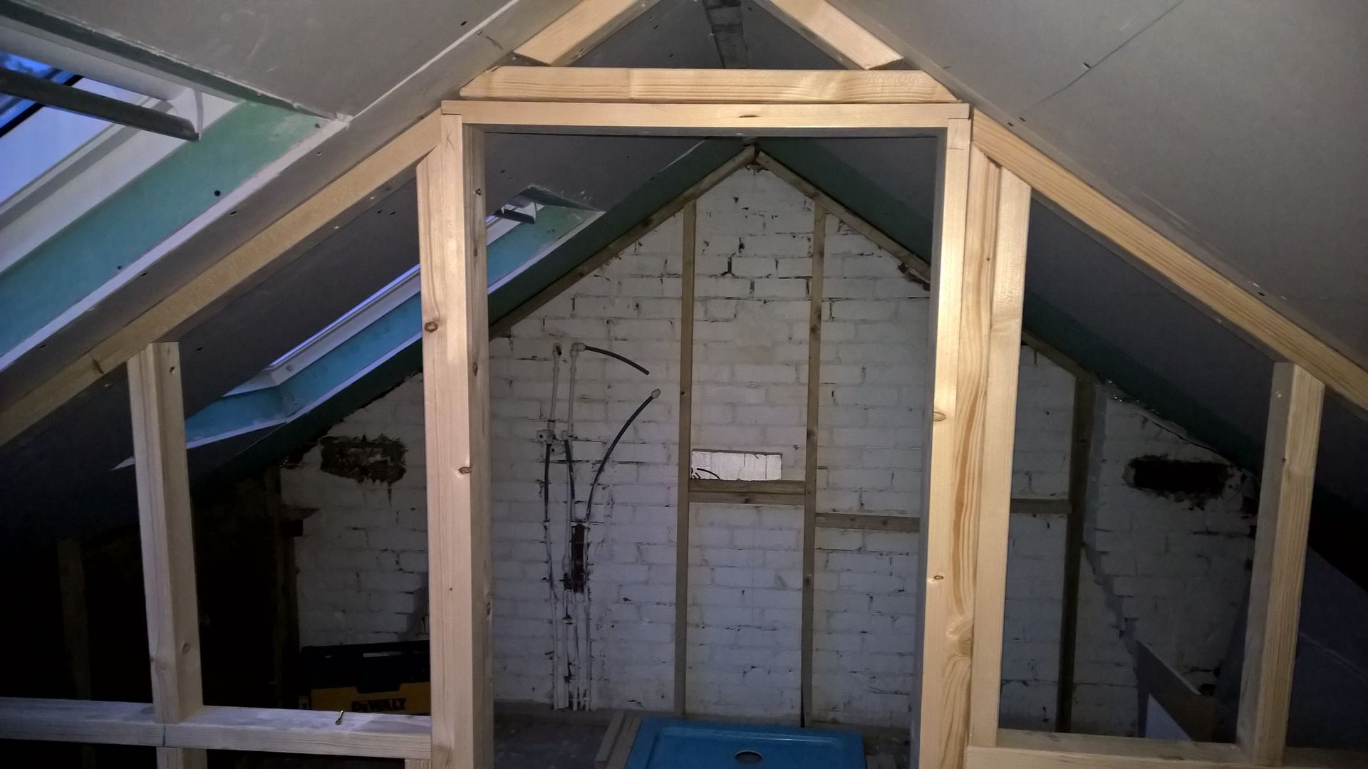 An attic with a brick wall and a wooden frame