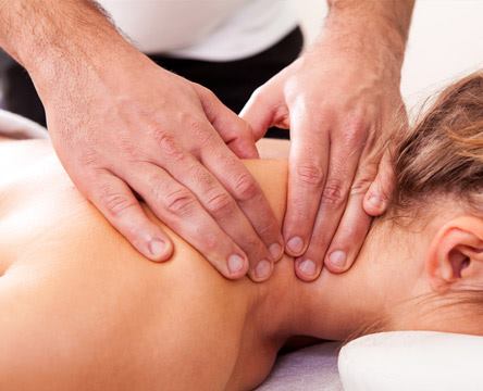A therapist's hands are massaging a lady's neck