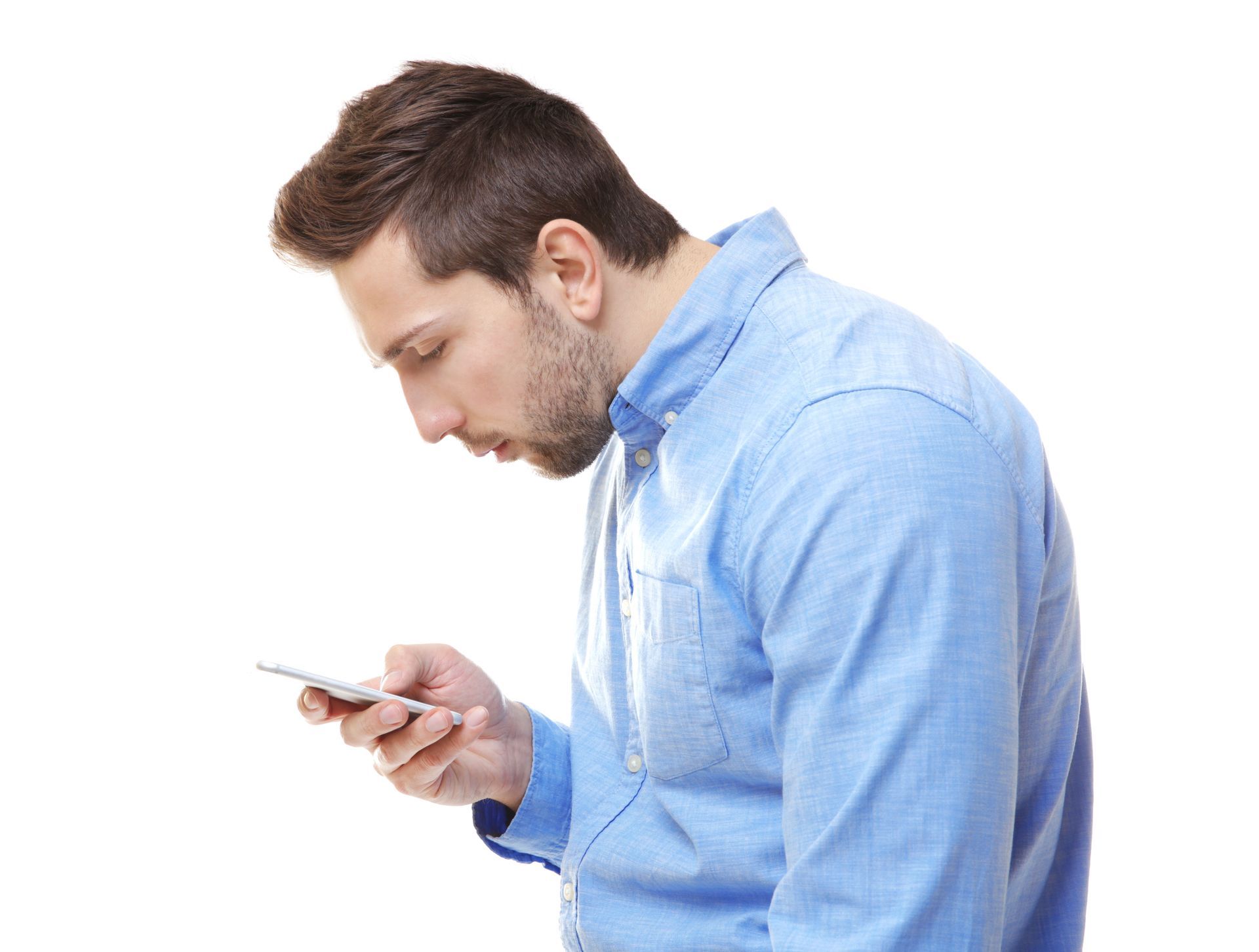 A young man holding a mobile phone in his right hand and looking down at the screen with a poor head and neck posture.