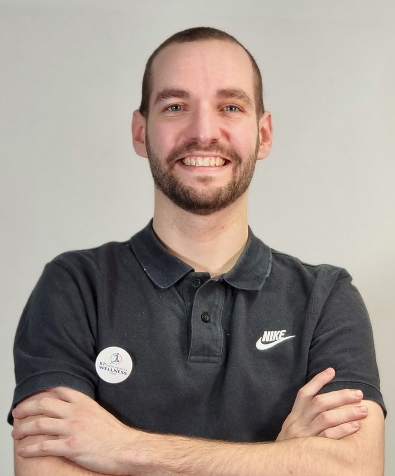 This is Tom's portrait in a black polo T-shirt. Tom is a qualified and insured massage therapist working at Rehab Pro Sports Injuries and Wellness Clinic in Manchester.