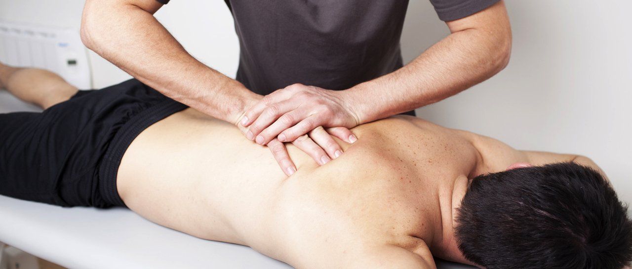 A therapist is applying hands pressure massaging client's back