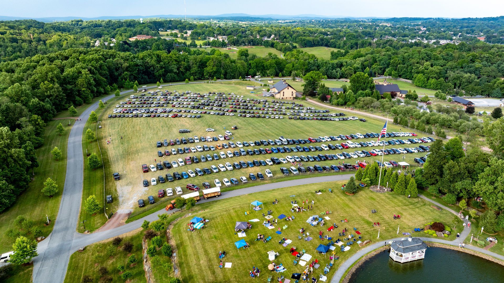An aerial view of a parking lot filled with cars and people.
