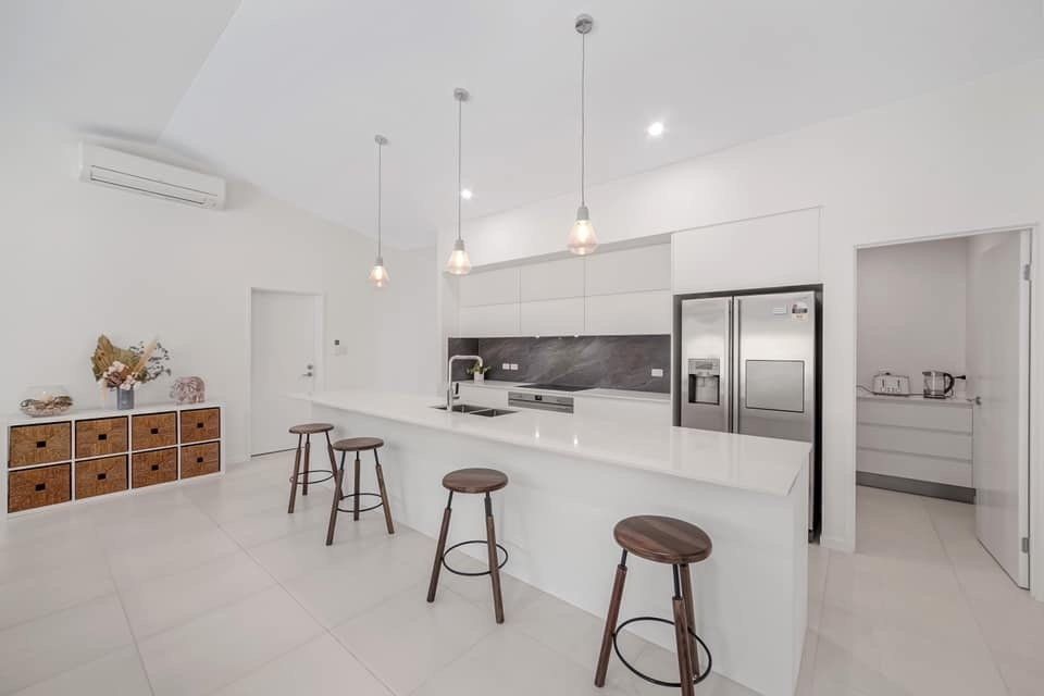 White Kitchen With Four Round Chairs — Kitchen Design in Edmonton, QLD