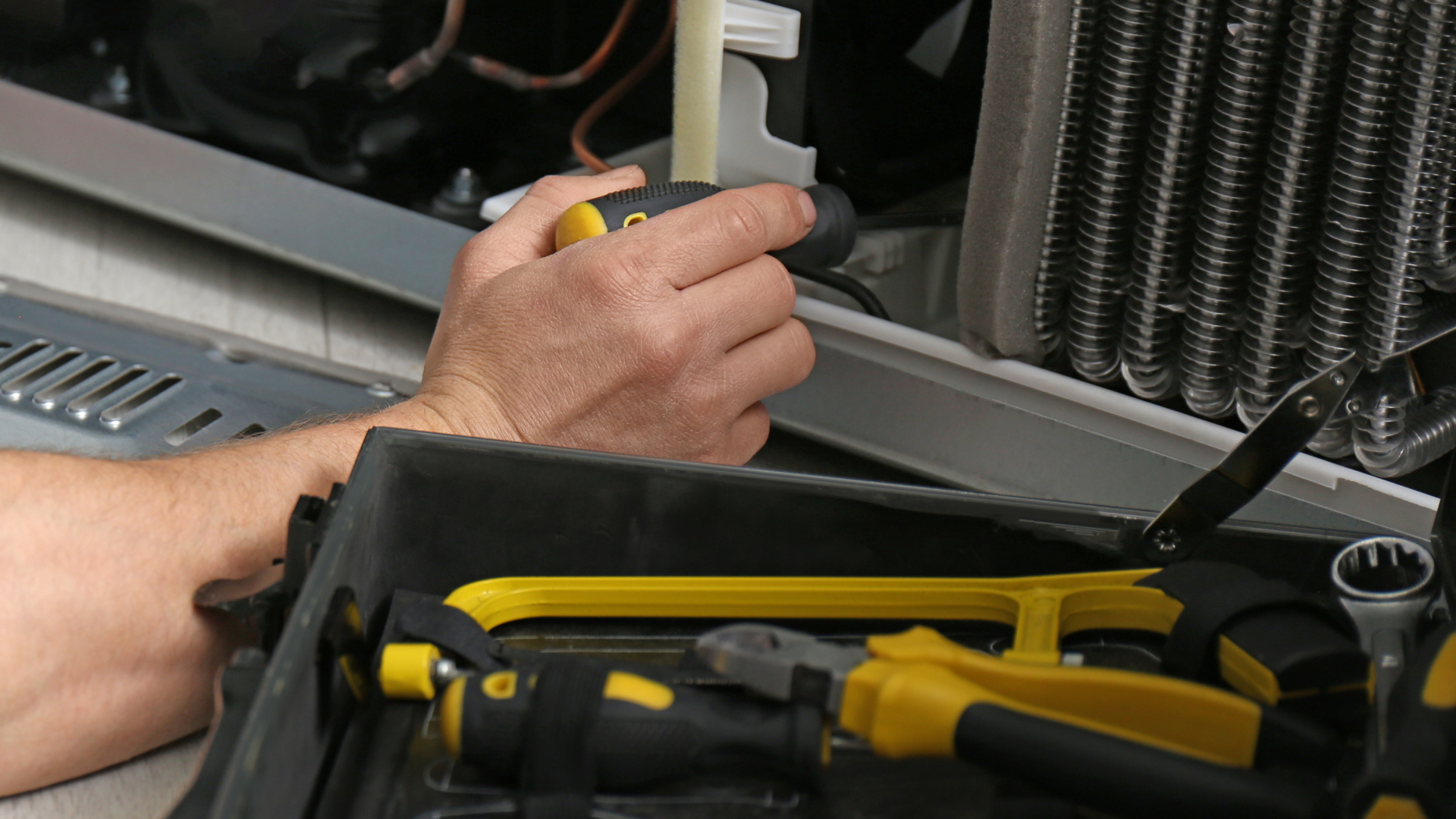 A man is working on a kitchen hood.