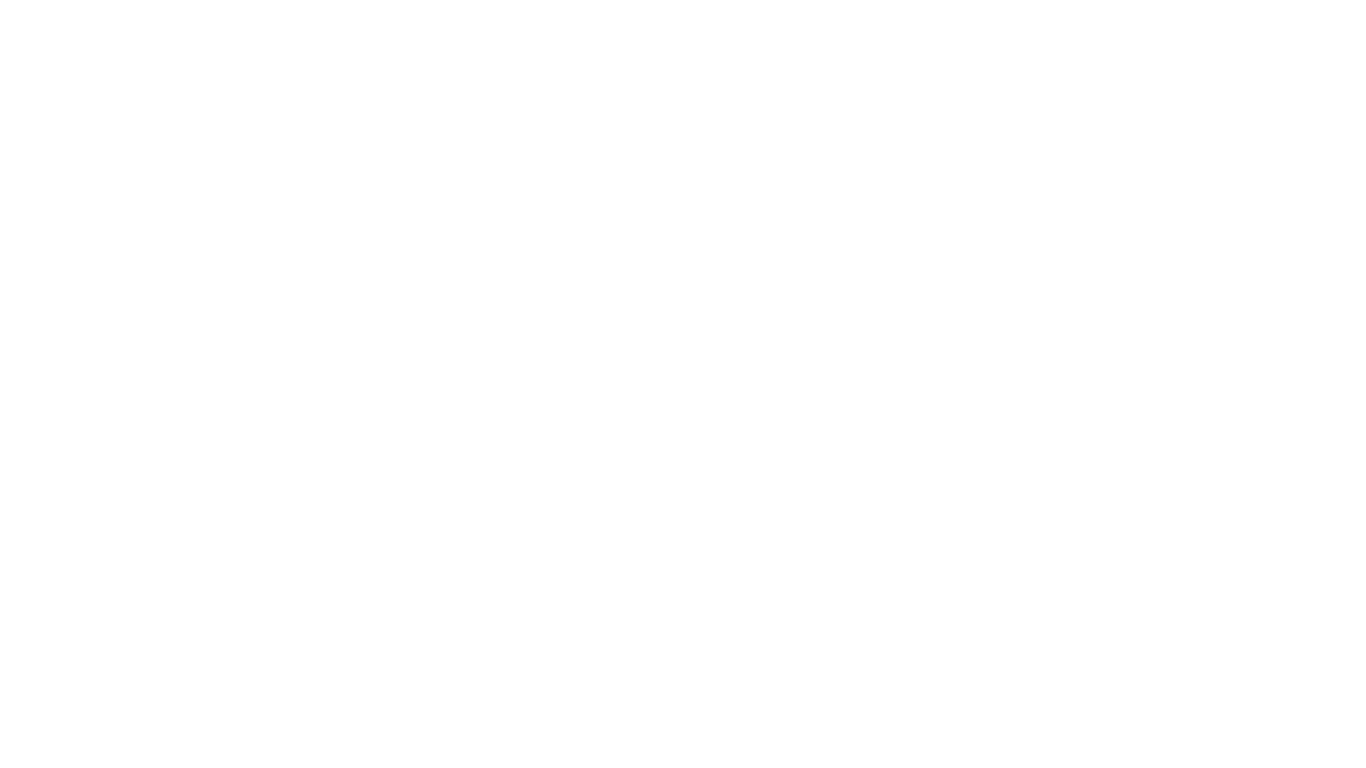 An orange traffic cone with a white reflective band sitting on an asphalt surface.