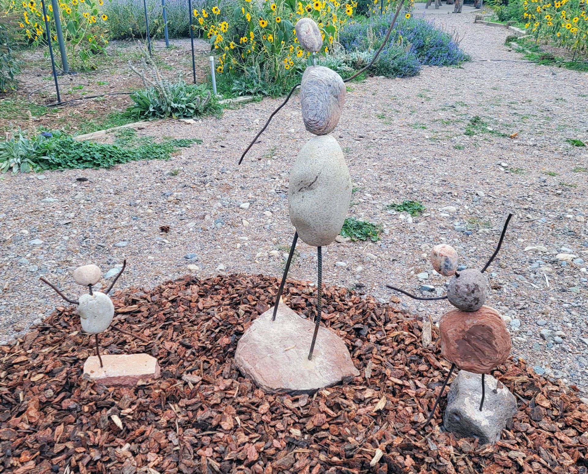 A group of rock sculptures are sitting on a pile of mulch.