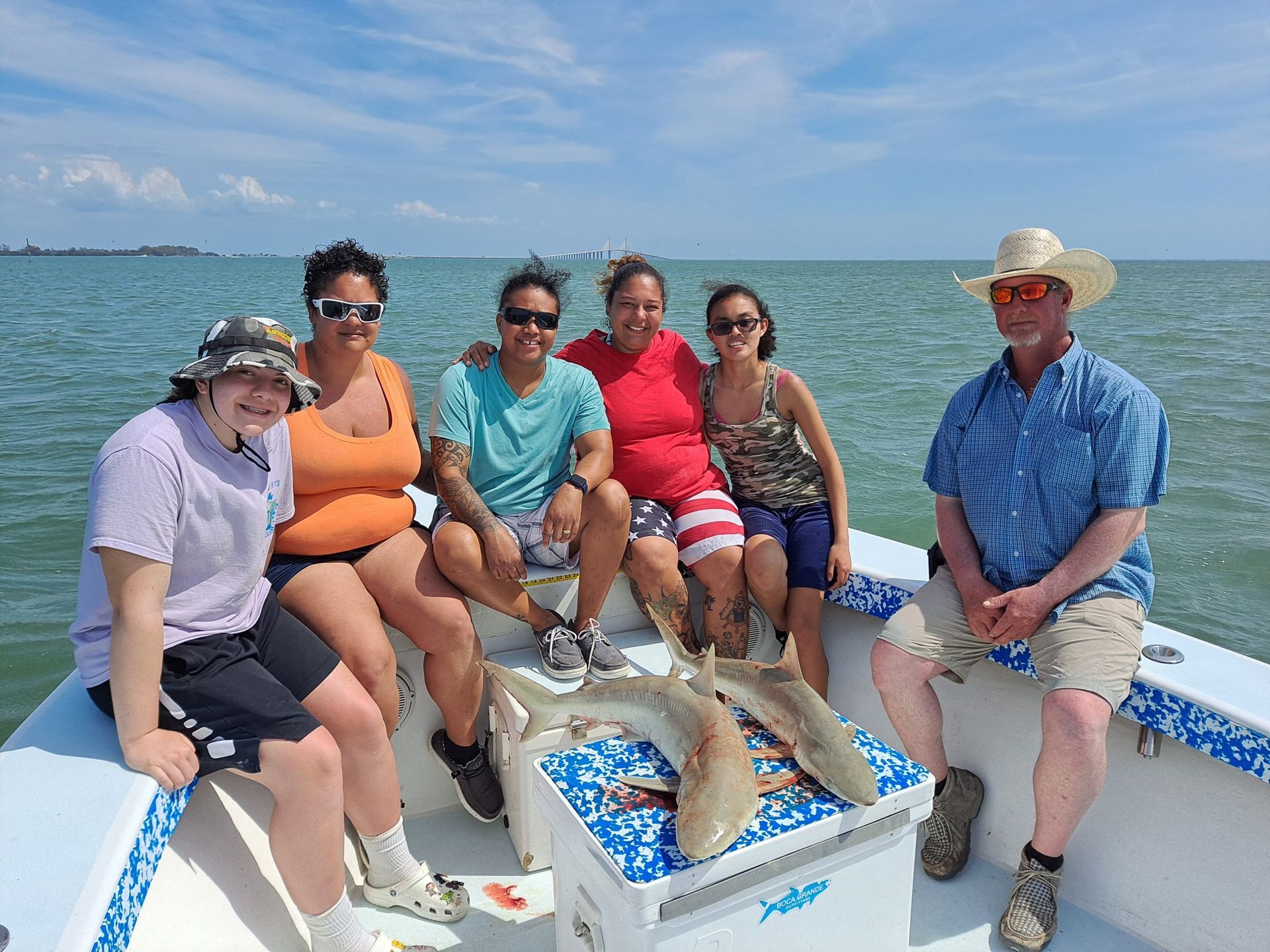 Group of people on a boat with fish. Sunny day at sea.