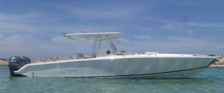 White motorboat on the water with blue sky.