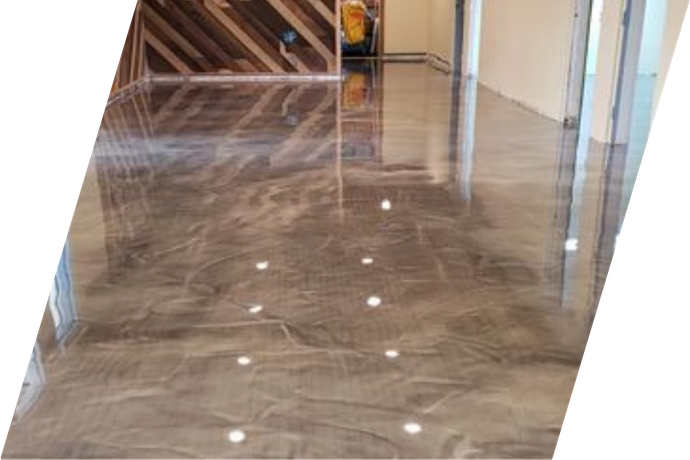 Metallic epoxy floor with subtle brown and silver swirls, reflecting ambient light.