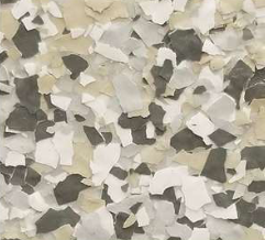 Close-up of a floor coating with speckled pattern of white, gray, beige and black chips.