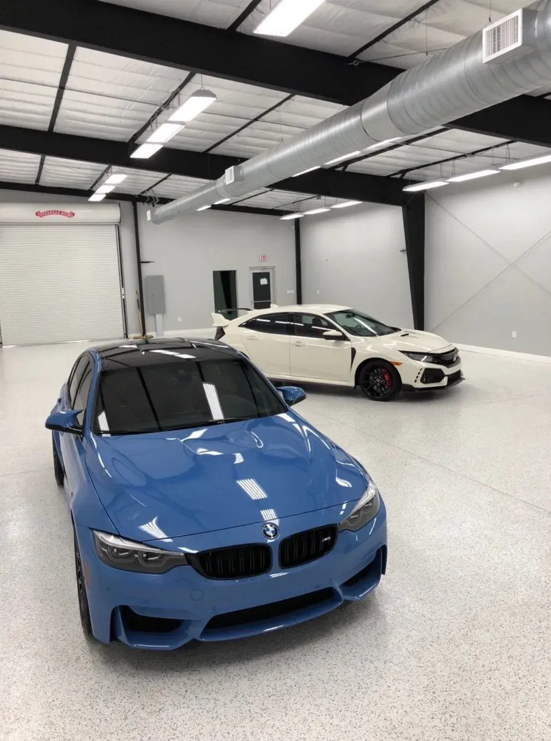 Blue BMW M3 and white Honda Civic Type R in a clean garage.