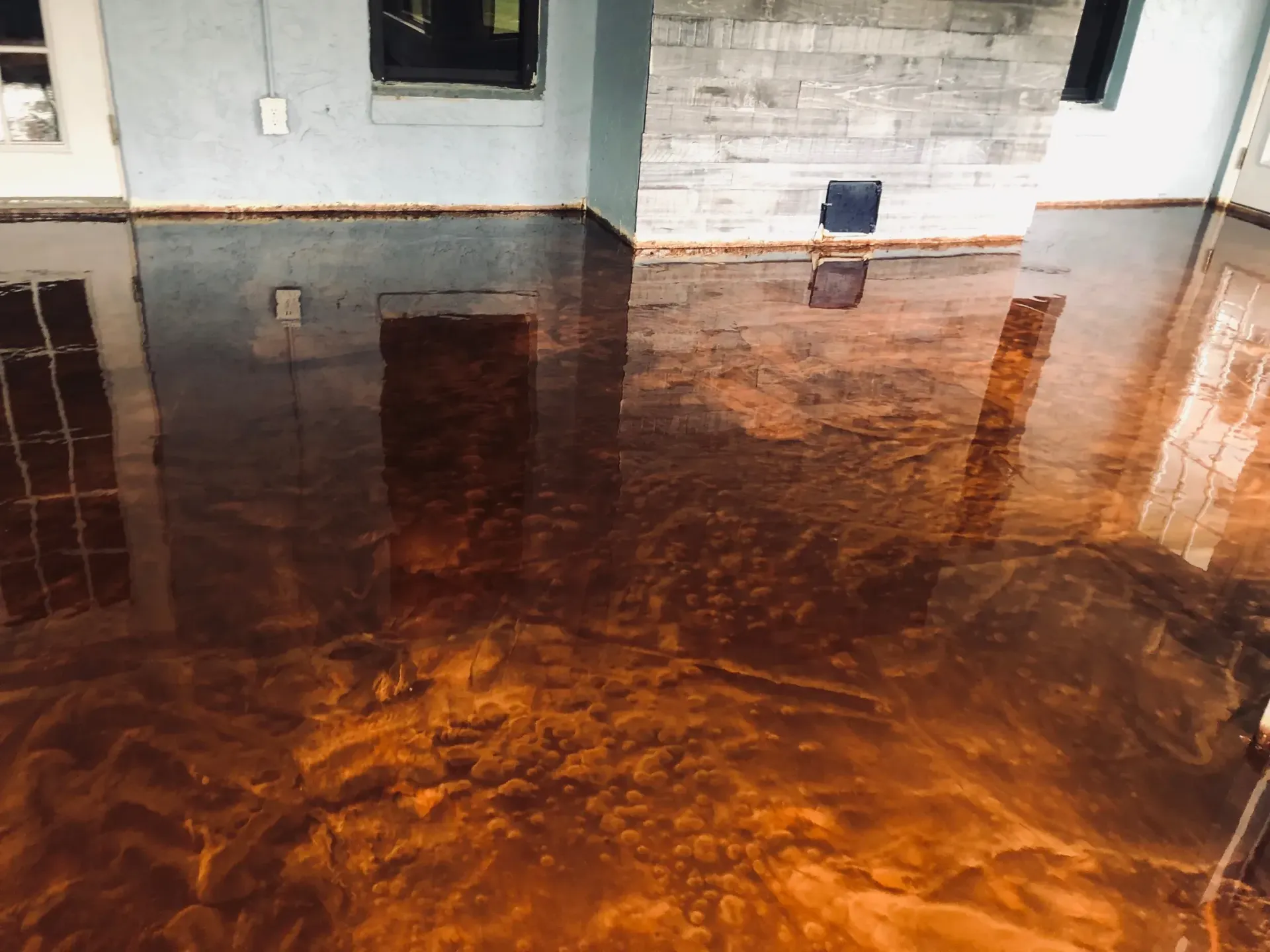 Metallic brown epoxy flooring reflecting the room's elements.