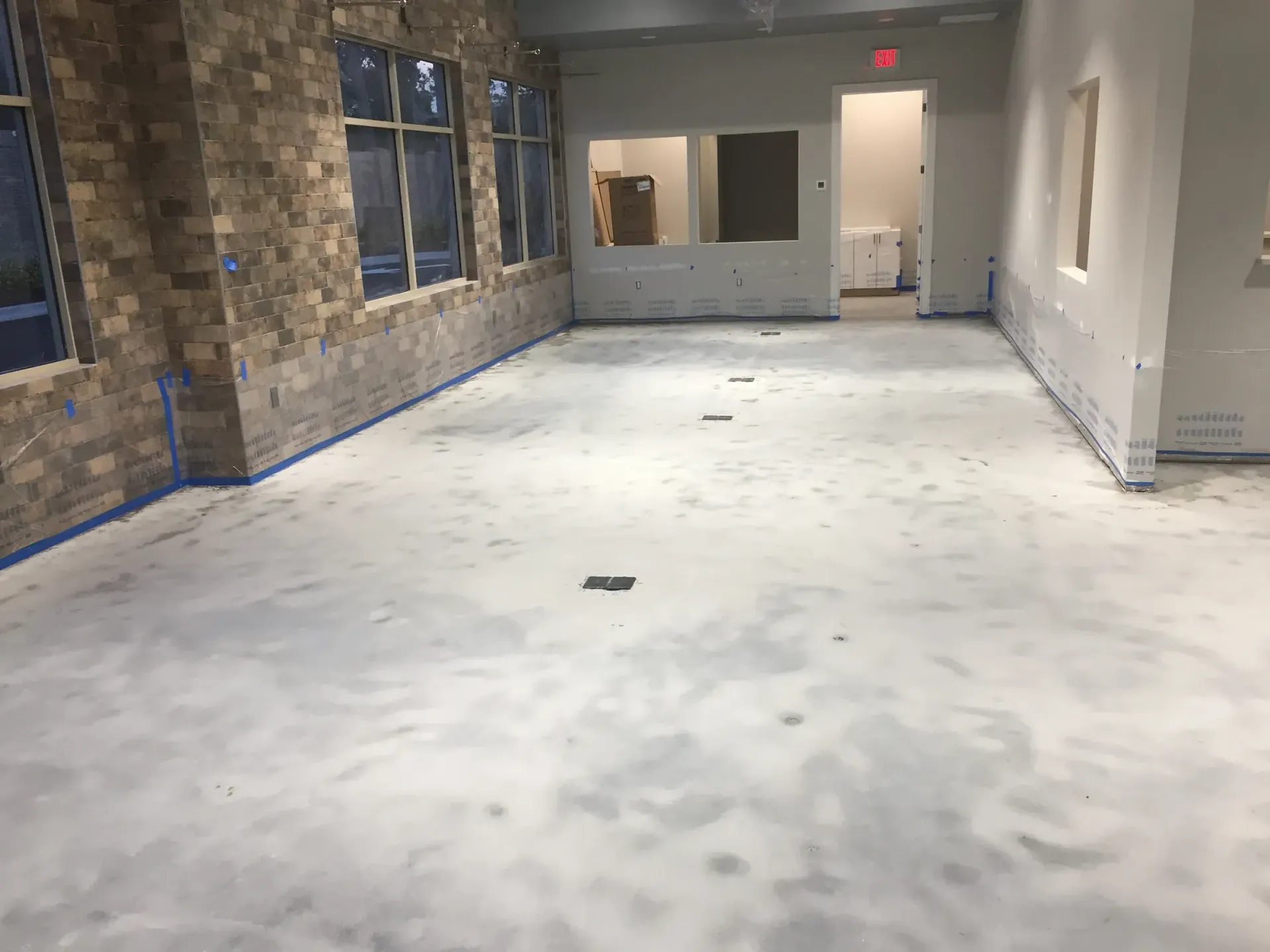 Empty room under construction with stone wall and concrete floor.