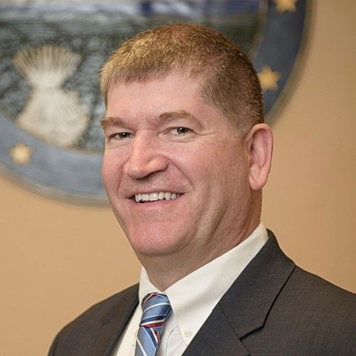 A person icon in a blue circle on a white background.