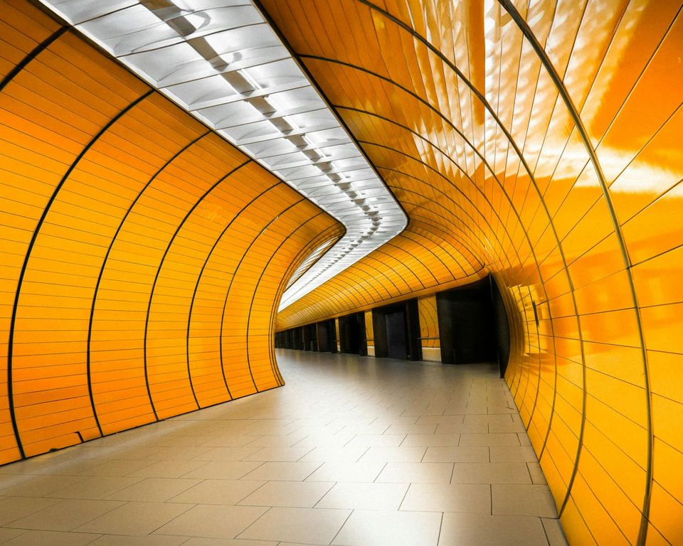 A tunnel with yellow walls and a white floor