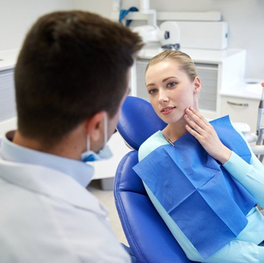 woman with tooth ache in dentist chair