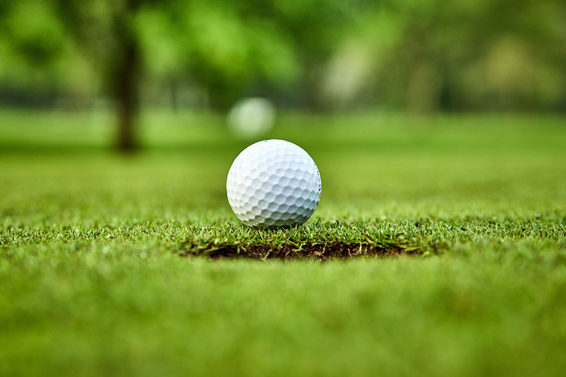 A white golf ball next to a hole on Tiger Point Golf Club in Gulf Breeze, FL