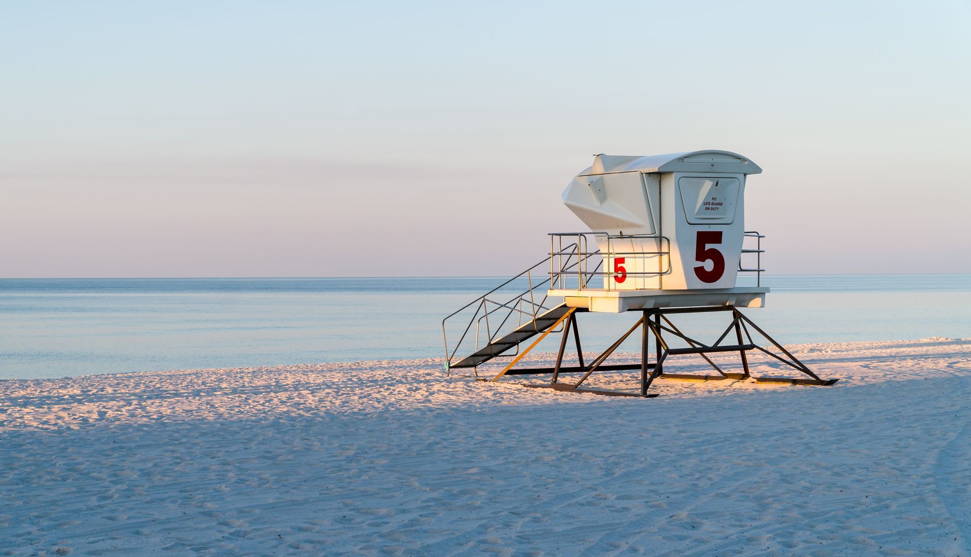 A lifeguard tower on a beach with the number 5 on it.