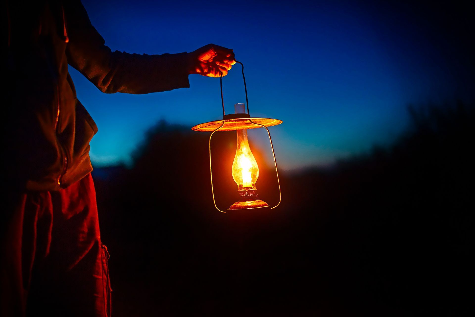 someone holding a lantern at night