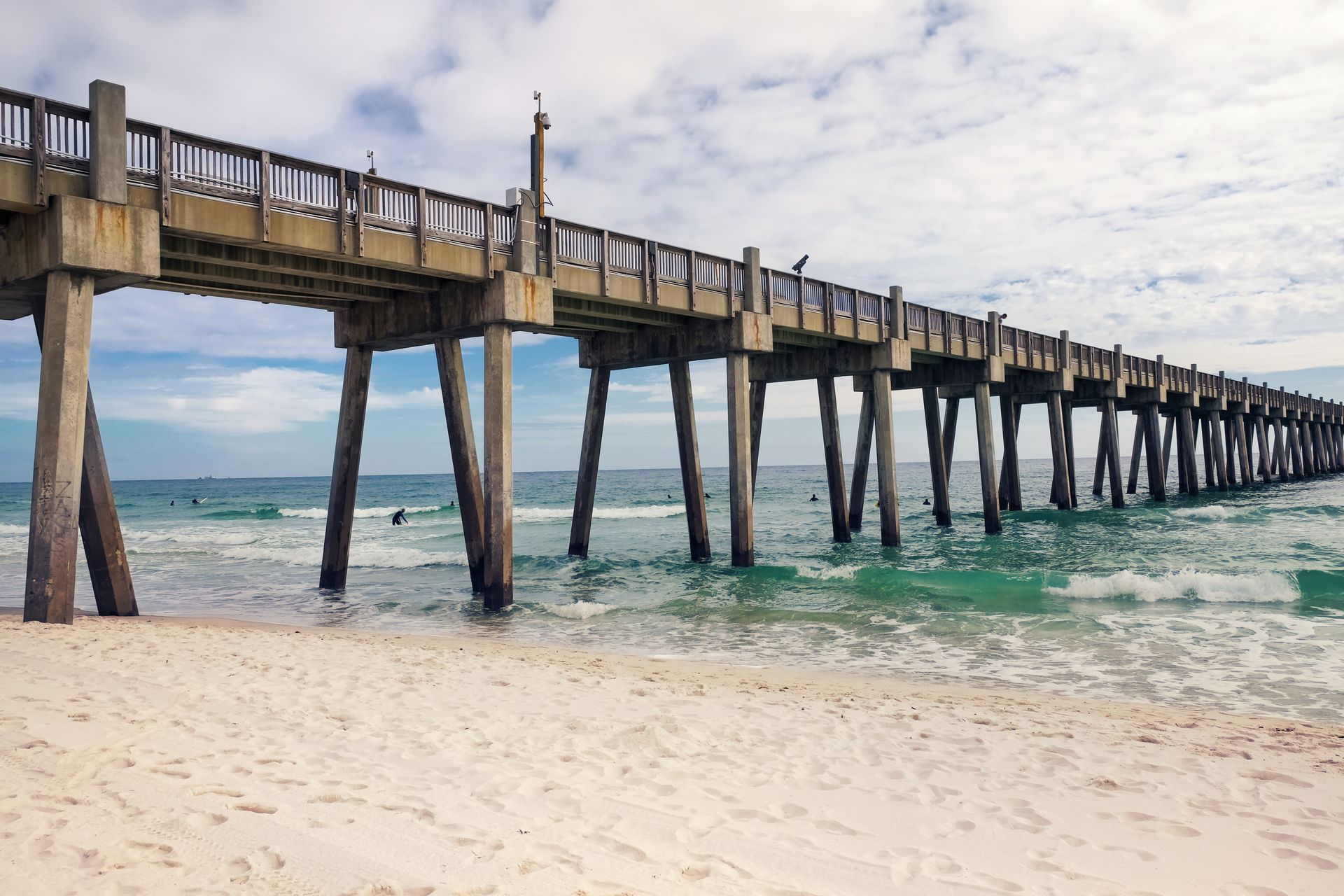 A pier leading into the ocean on a beach