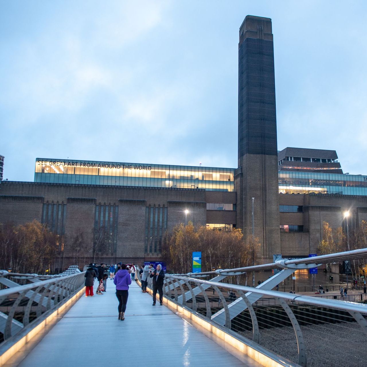 Tate Modern in London with its iconic brick façade and tall chimney by the River Thames.