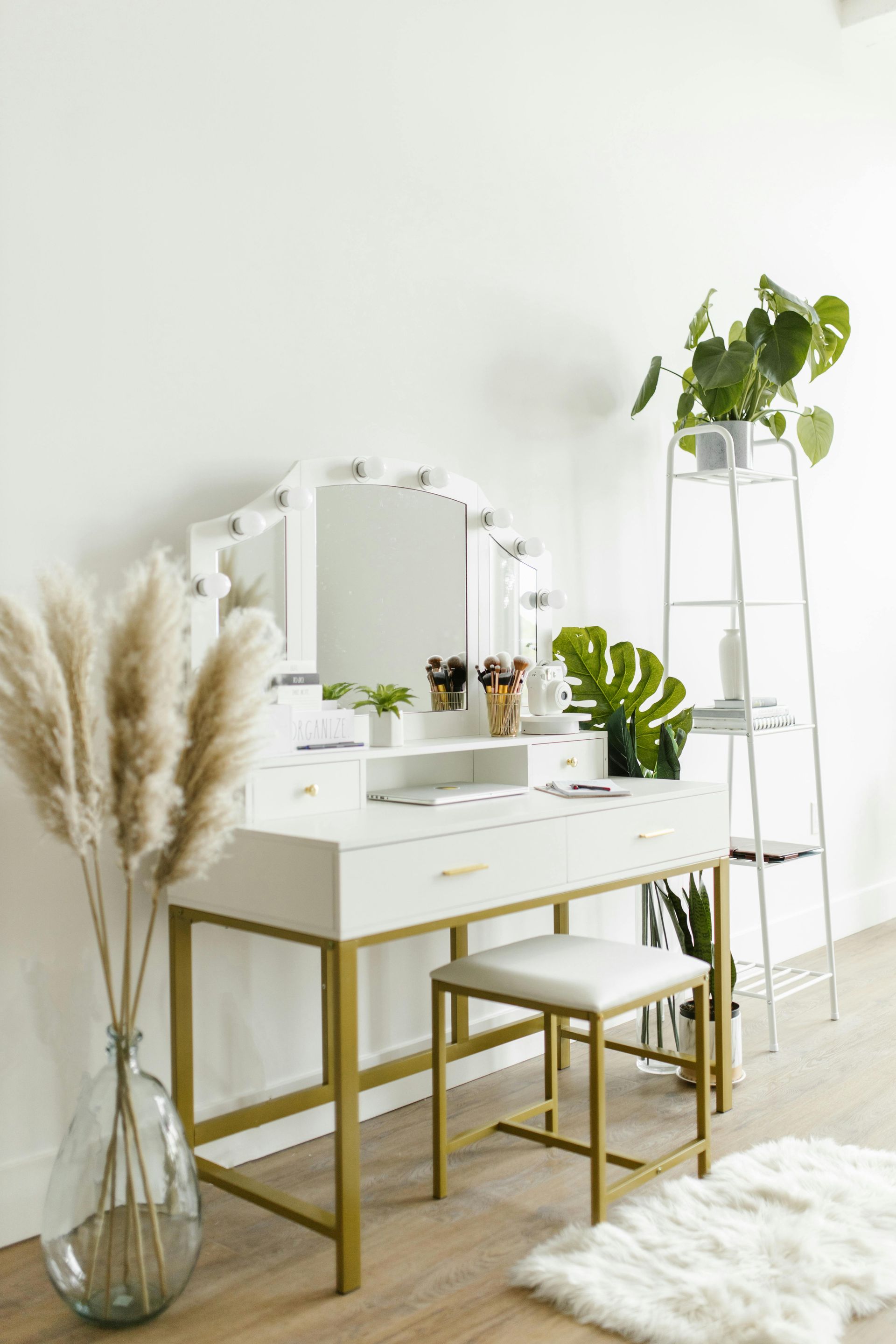 There is a vanity with a mirror and a stool in the room.