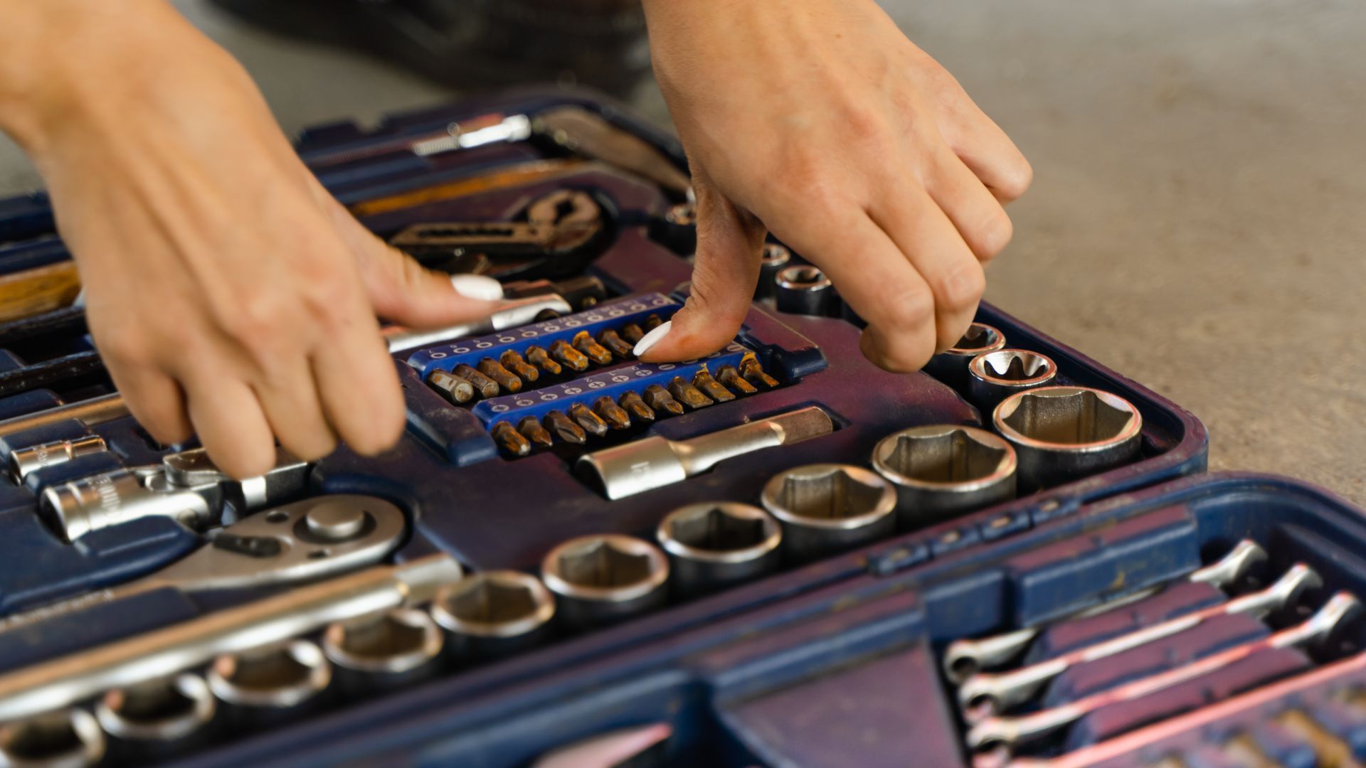A man in red overalls is working on a garage door.